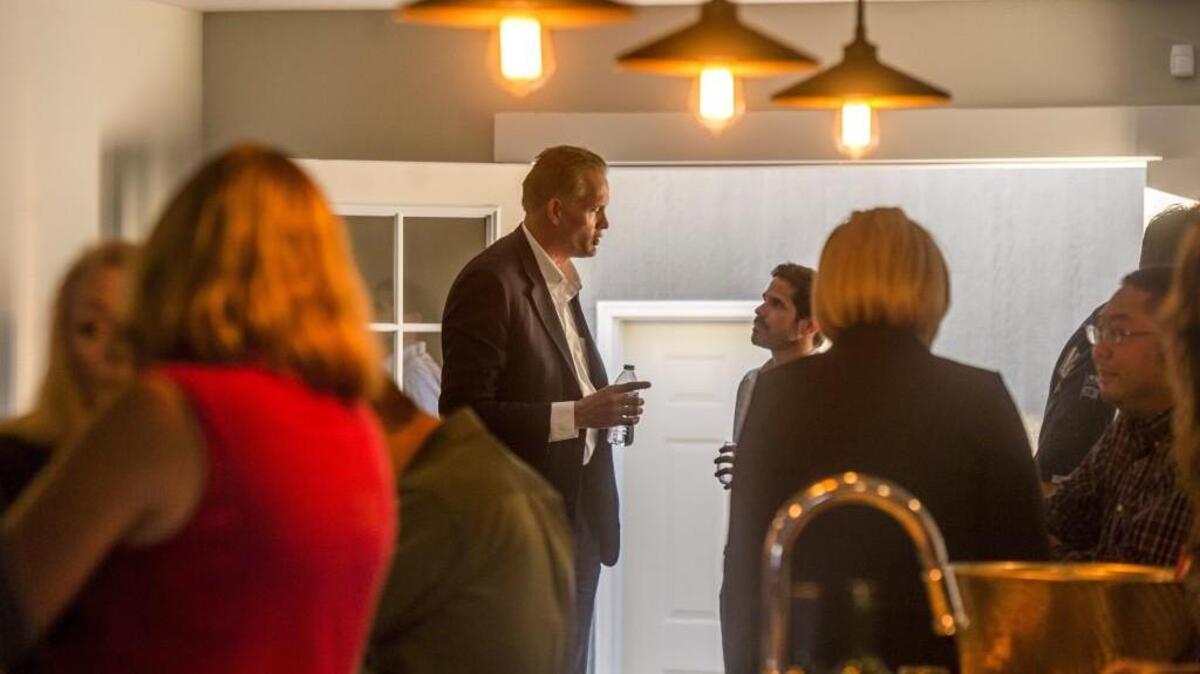 Pierce County Prosecutor Mark Lindquist, left, chats at a fundraiser held by the 27th District Democrats. Lindquist is a Democrat, but a proposal that died before the Pierce County Council last week would have changed the prosecutor to a nonpartisan office.