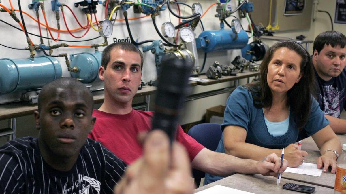 Students in a truck training program at Bates Technical College in Tacoma, (from left) Ronald Foster, Clayton Foster, Vicki Arnold, and Skipper Kuzior, learn about fuel injectors during a lecture on diesel engines.