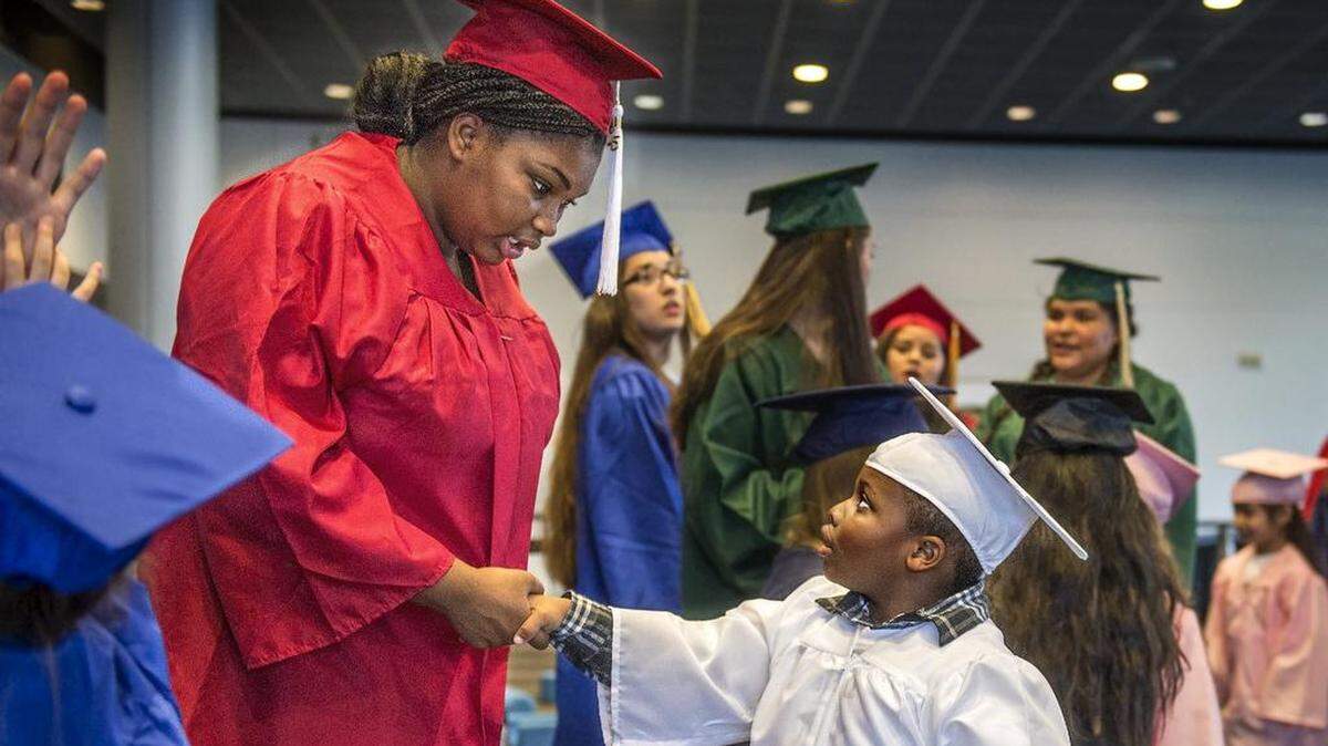 Future Tacoma high school graduates from different age groups connect at a public event in 2016. Whitman Elementary School kindergartener Cavali Davis (Class of 2029), right, gives his undivided attention to Mount Tahoma student Aniya Critton (Class of 2020). Washington graduation requirements could change before any of these students cross the stage and are handed their diplomas.