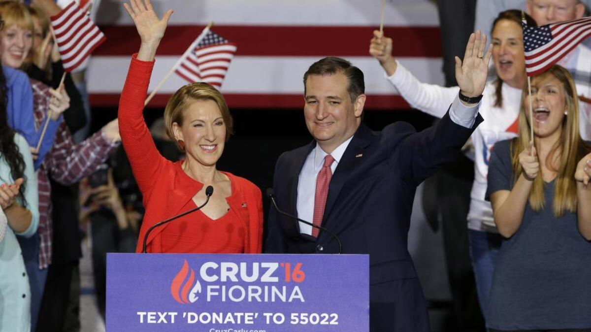 Republican presidential candidate Sen. Ted Cruz, R-Texas, joined by former Hewlett-Packard CEO Carly Fiorina waves during a rally in Indianapolis Wednesday, when Cruz announced he has tapped Fiorina to serve as his running mate.
