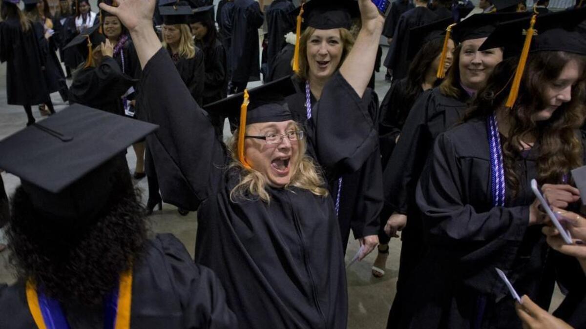 Kelly Sommer of Rochester raises her arms in celebration with her classmates in the nursing school for the University of Washington Tacoma graduation at the Tacoma Dome in 2012. A new program by the local nonprofit Degrees of Change aims to attract or keep more graduates in Tacoma to launch careers.