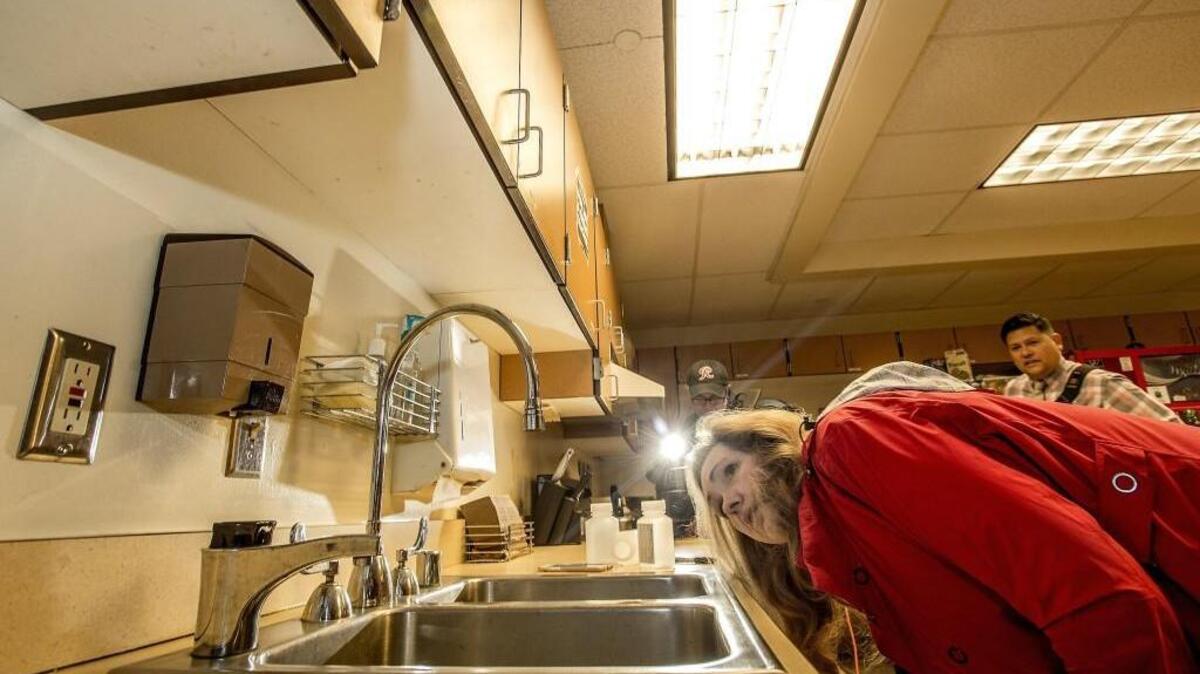 Donna McNeal, from Orion Environmental Services of Federal Way, examines a faucet before taking a sample to test for lead in a Tacoma school in 2016. This was one day after Tacoma School District officials revealed high lead levels were detected in previous samples at Mann and Reed elementary school.