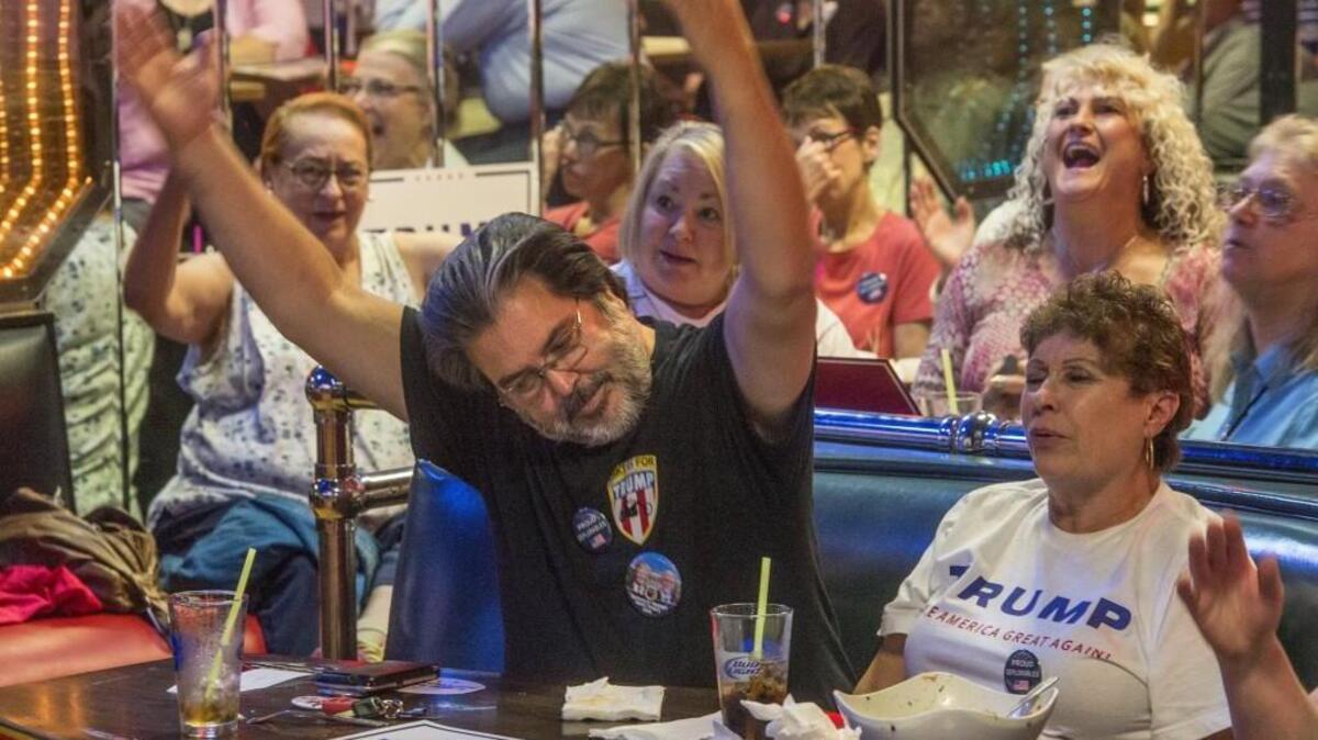 Michael and Carol Garcia react with applause along with other Donald Trump supporters in September during a Pierce County Republican debate viewing party at Cheers Bar & Grill in Lakewood, when the first presidential debate between Trump and Hillary Clinton was aired. Trump will now represent all of America, including a majority of Washington state residents who disapproved of his candidacy.