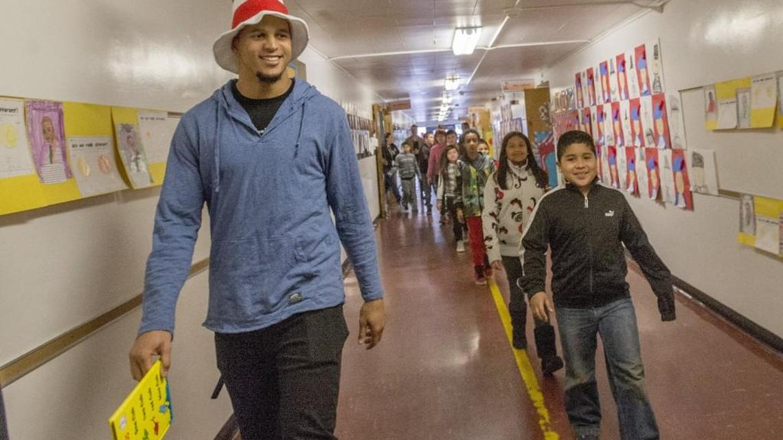 Former Seattle Seahawks receiver and Lakewood resident Jermaine Kearse walks with students after reading Dr. Seuss’s “One Fish, Two Fish, Red Fish, Blue Fish” at Lakewood’s Tillicum Elementary School on Read Across America Day.