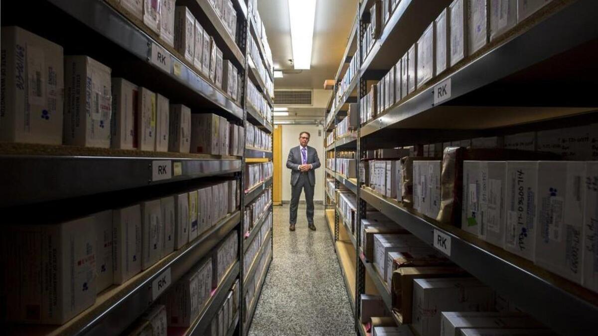 Tacoma Police Det. Bradley Graham of the department's Special Assaults Unit stands among shelves of "rape kits," some of which have never been tested for lack of resources. August 24, 2017.