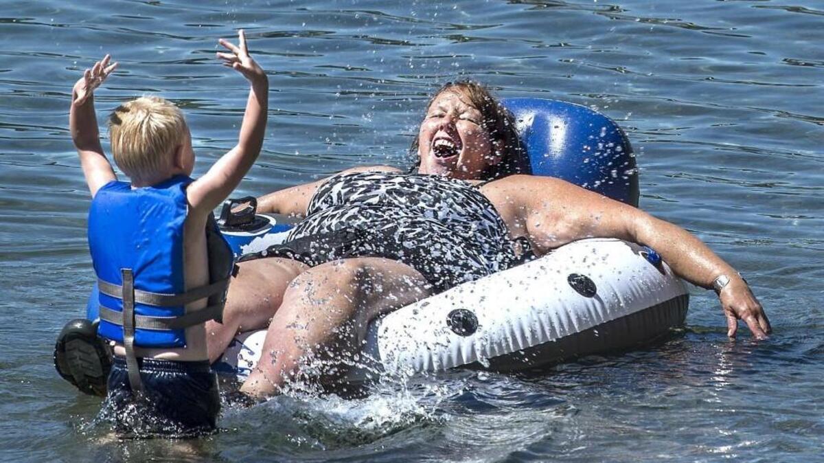 Denise Parfitt of Parkland lets out a loud squealing sound as she was splashed by her nephew 3-year-old Quintez Parfitt at American Lake Park in Lakewood last July.