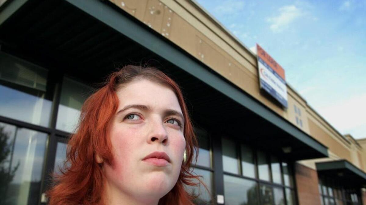 Toni Cornell, a former Business Computer Training Institute student, stands in front of the former BCTI facility located in a strip mall in Tacoma. Cornell accumulated $7,000 in debt from attending the school, which closed in 2005.