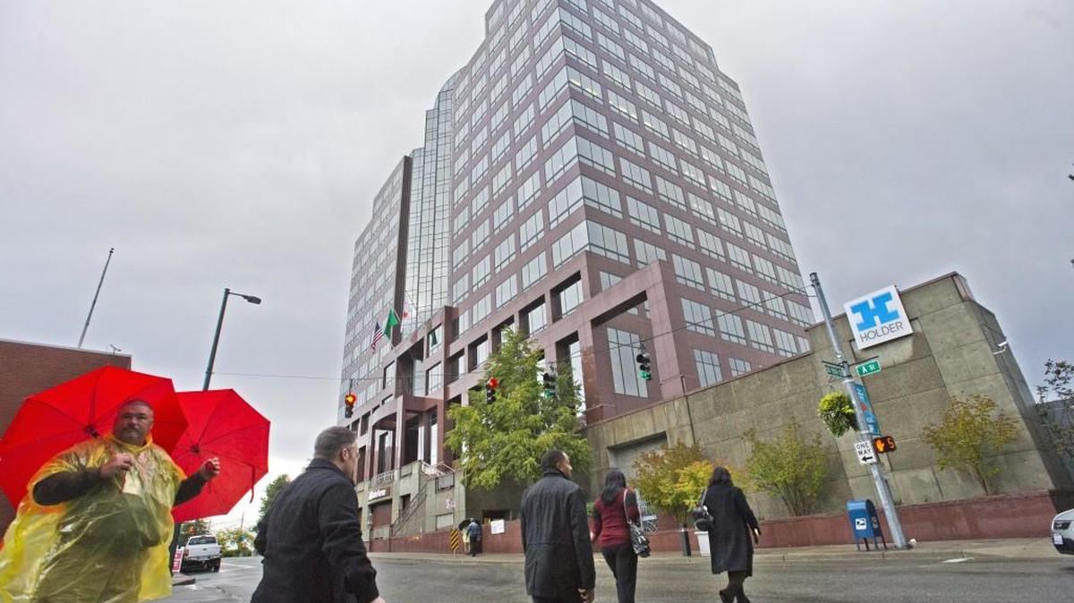 Employees arrive at State Farm offices in downtown Tacoma. It was the first day of work for about 300 employees in the former Russell Investments headquarters. State Farm had greeters with umbrellas on the street.