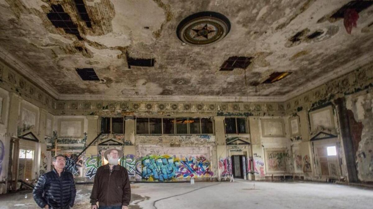Mike McMenamin (right), co-owner of McMenamins, a Portland-based developer of brew pubs and hotels, and architect George Signori take a look around the weathered ballroom of the Elks Lodge in downtown Tacoma two years ago. Though a projected opening date has been fluid in the past, the McMenamins now say they have the investment capital to open their Elks venue in 2019.