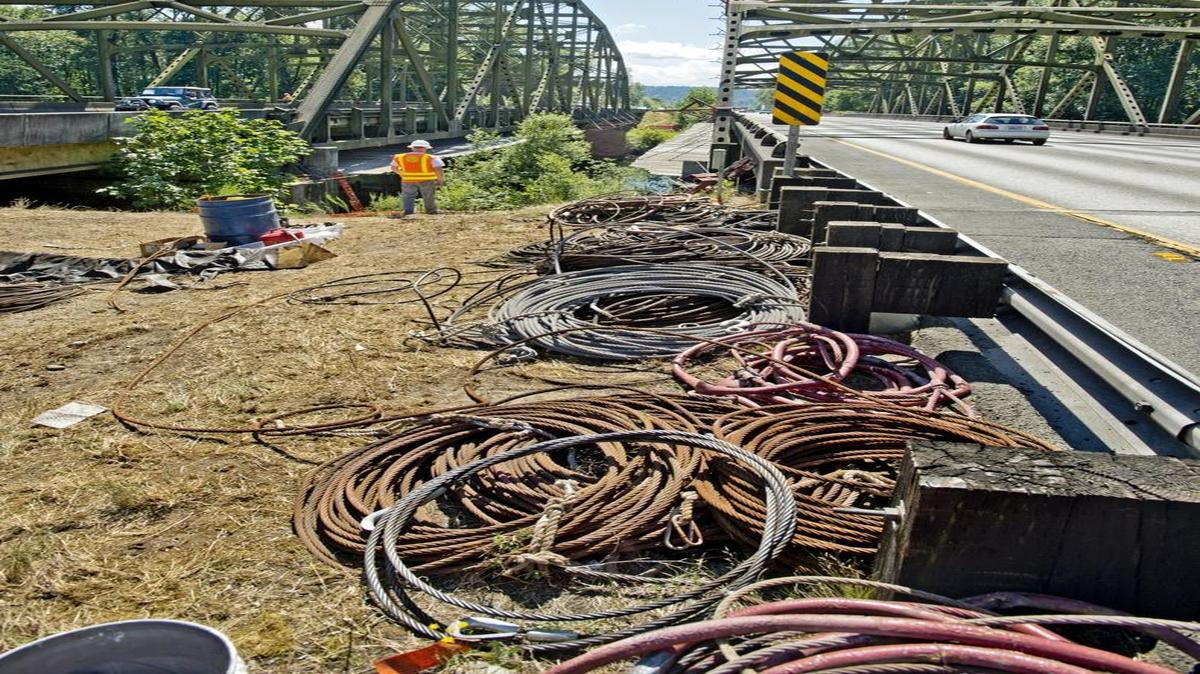 Cables and other gear await placement by the Interstate 5 bridges over the Nisqually River, July 11, 2013.  The state Department of Transportation has hired a contractor to sand blast and paint both bridges.  The top of the southbound bridge (right) has brackets that will hold tenting necessary to keep the sand and paint from dropping into the river.
