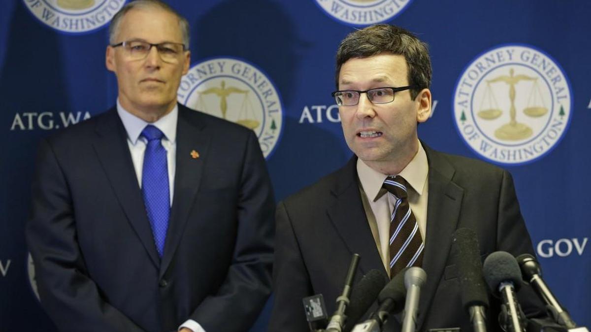 Washington Attorney General Bob Ferguson, right, talks to reporters as Gov. Jay Inslee looks on, Monday in Seattle. Ferguson announced that he is suing President Donald Trump over an executive order that suspended immigration from seven countries with majority-Muslim populations and sparked nationwide protests.