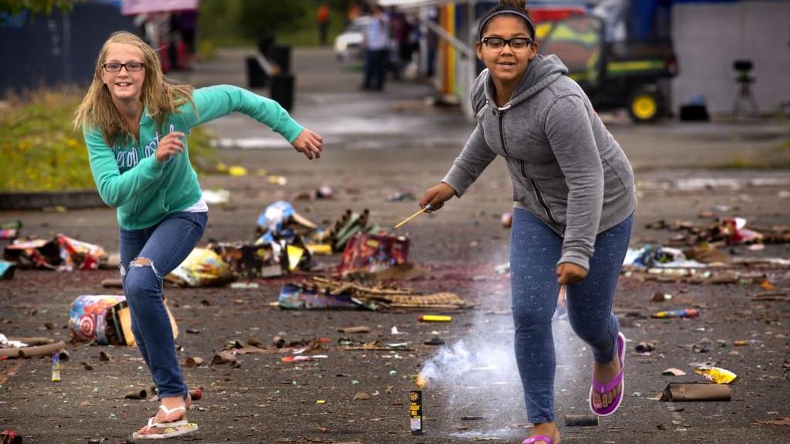 Two girls sprint away after setting off a firework at the old Emerald Queen Casino site in 2013. Different cities have different rules for what's legal and what's not when it comes to fireworks.