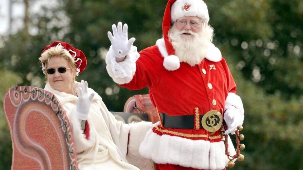 Santa and Mrs. Claus show their mutual appreciation for the Five Spot column while riding at a community Christmas parade.