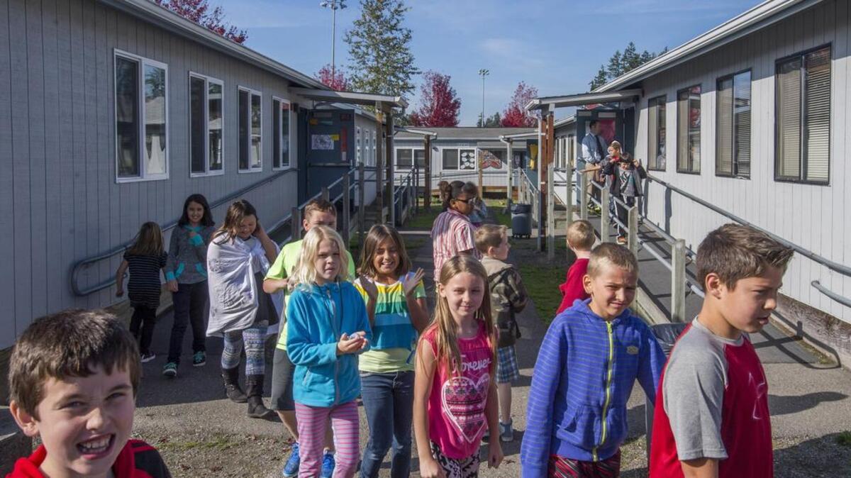 Fourth-graders stream out of portable classrooms at Zeiger Elementary in South Hill Oct. 15. The school has 11 classes and programs in portables.