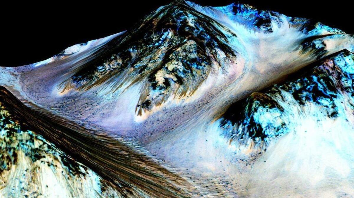 
Photo taken by an instrument aboard NASA’s Mars Reconnaissance Orbiter shows dark, narrow, streaks on the surface of Mars that scientists believe were caused by flowing streams of salty water. Researchers say the latest observations strongly support the longtime theory that salt water in liquid form flows down certain Martian slopes each summer. 
