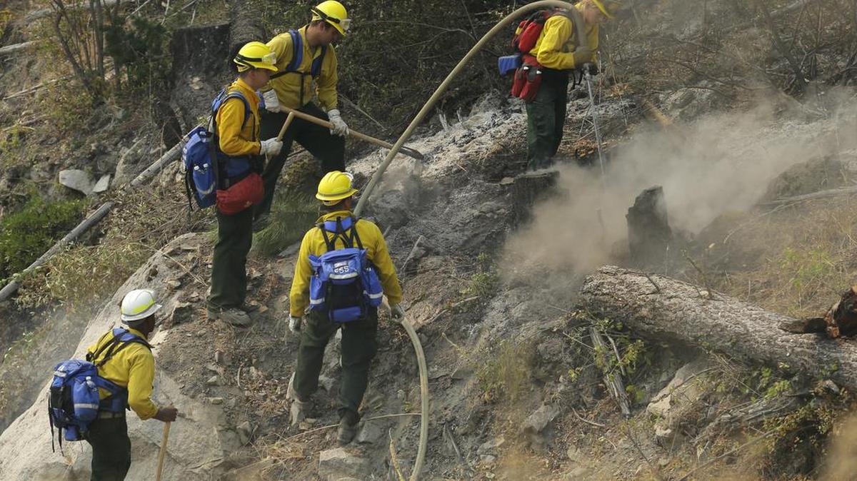 
Firefighters and Washington National Guard soldiers work to extinguish hot spots on a hillside as they fight the First Creek Fire Wednesday near Chelan, Eastern Washington. 
