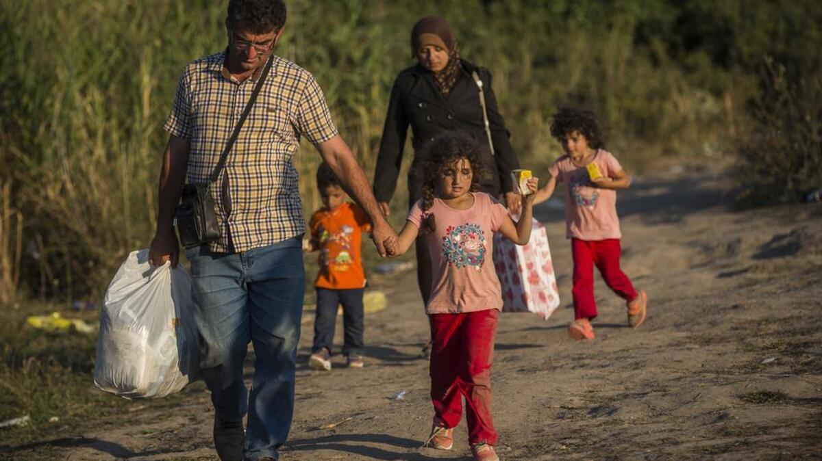 
Syrian refugees cross the border from Macedonia to Serbia on Aug. 28. 

