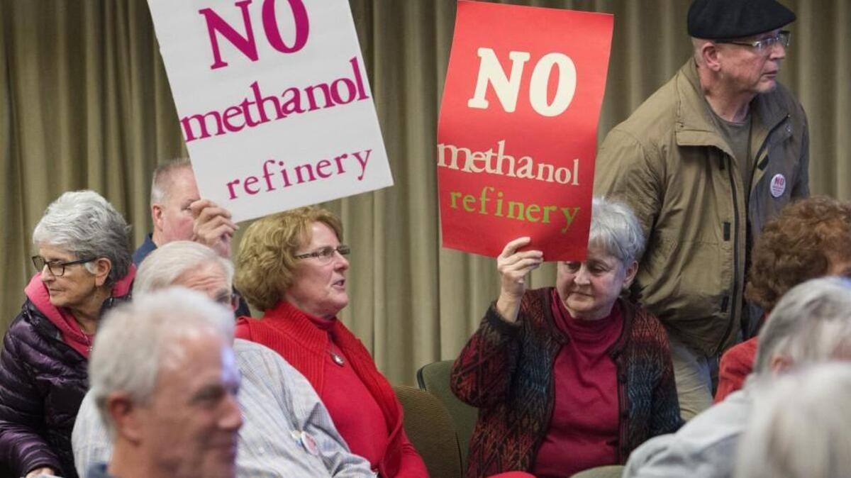 People opposed to a methanol plant on the Tacoma Tideflats wield signs at a Port of Tacoma Commission meeting on Thursday, Jan. 28, 2016.