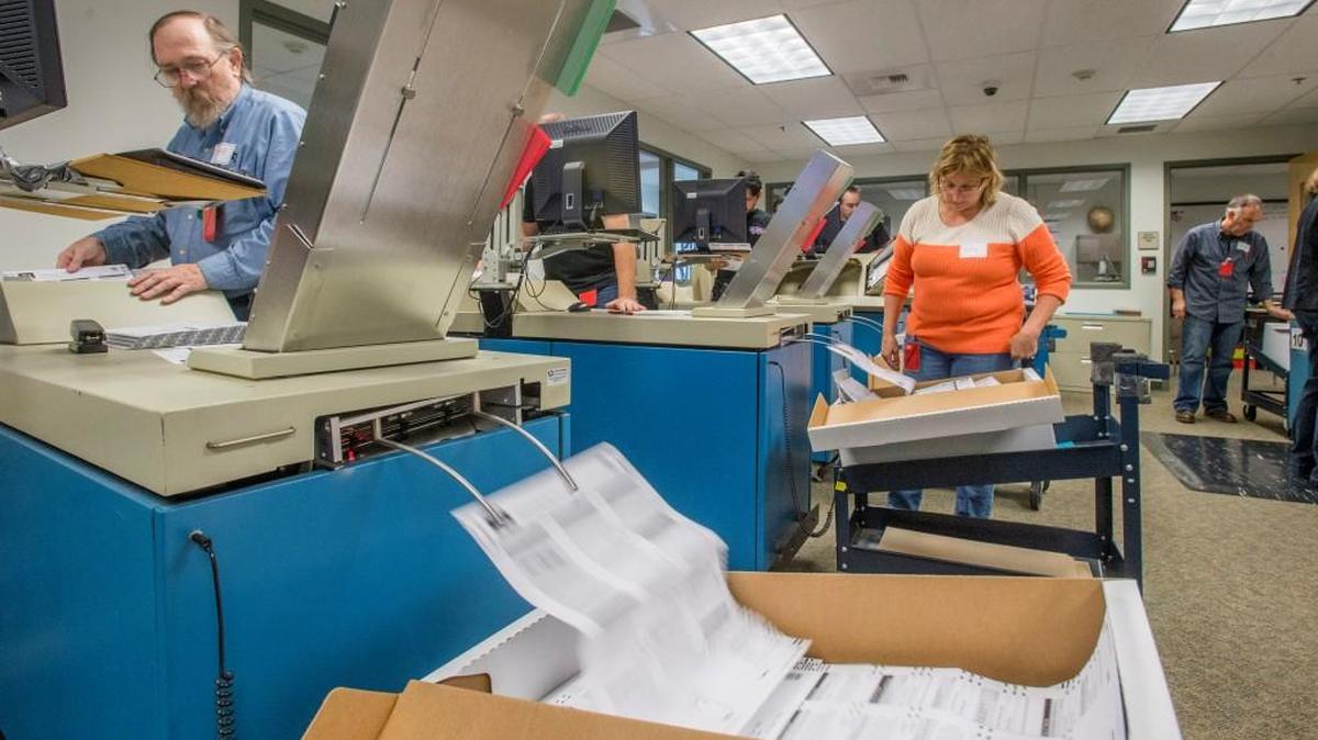 Election workers scan ballots Tuesday in the tabulation area of the Pierce County Elections Center.
