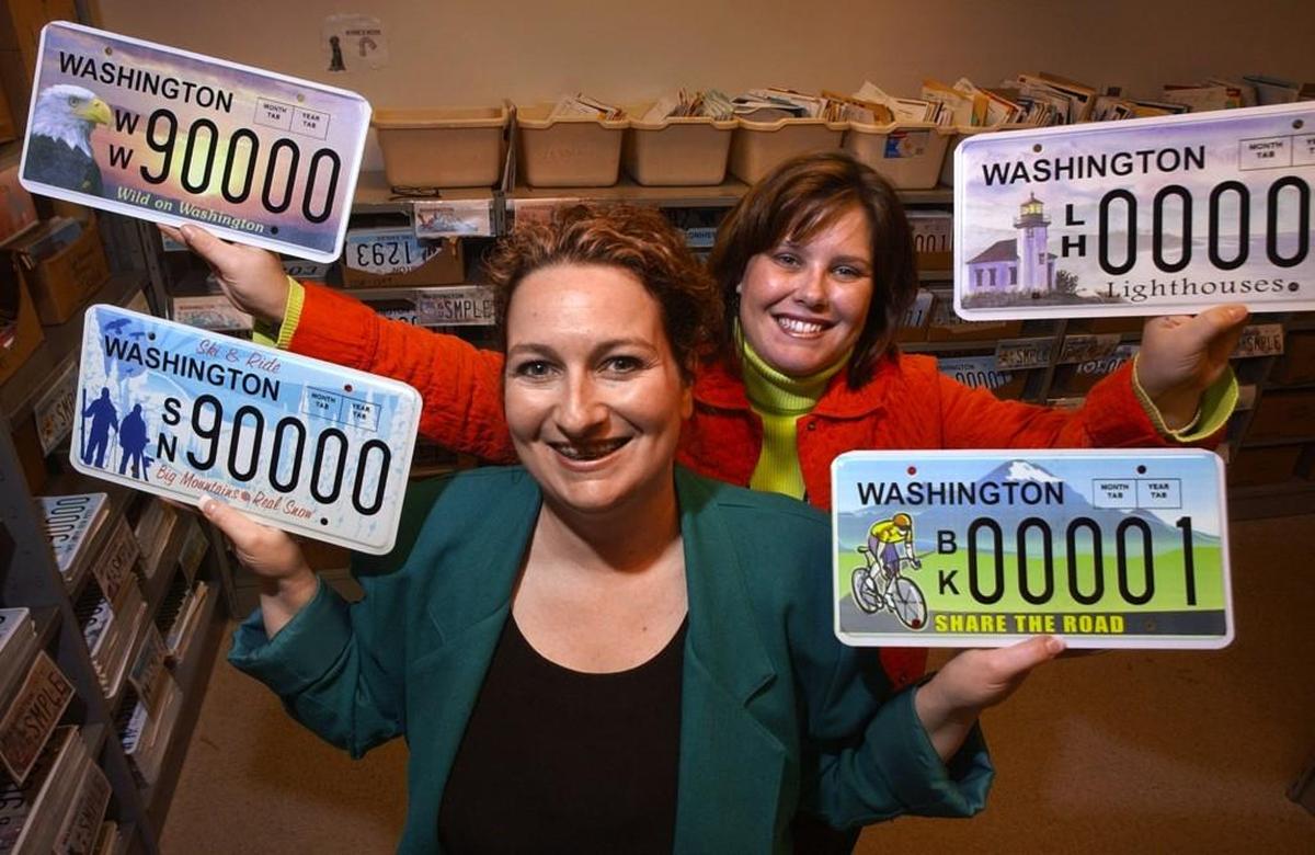 State licensing employees Jennifer Dana, front, and Alyson Chase show off some of the 18 new specialty license plates that were available to the public in 2006. 