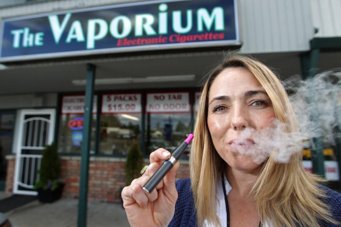 Kim Thompson exhales vapor from her e-cigarette outside the Vaporium in Lakewood. Washington’s tobacco products tax applies to any product that contains tobacco or nicotine,” effective Jan. 1, 2026.