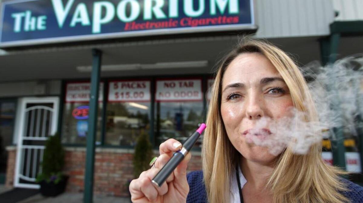 Kim Thompson exhales vapor from her e-cigarette outside the Vaporium in Lakewood. Thompson, a 20-year smoker, opened the business in 2011 selling electronic cigarettes or personal vaporizers as an alternative to traditional cigarettes. Pierce County imposed new regulations on vaping businesses this year. Now the state will take over.