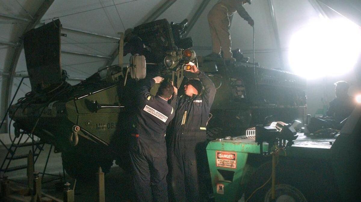 Private contractors are shown in December 2005 disassembling Stryker vehicles that made it through two years of combat in Iraq and getting them ready for use once again. Around 900 civilian employees and contractor jobs are now on the chopping block at Joint Base Lewis-McChord.