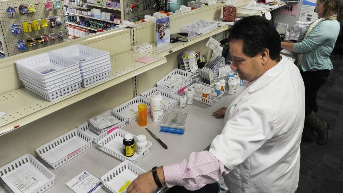 West Olympia Pharmacy owner and pharmacist Jim Perrou prepares prescriptions with technician Kim Casebolt in December 2015. Proposed legislation would allow trained pharmacists to dispense contraceptives without a doctor’s prescription.