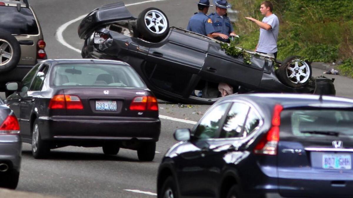 Washington State Patrol troopers try to sort out the details of a roll-over accident near the southbound Interstate 5 exit to downtown Olympia that made 2013 Labor Day traffic just a bit more challenging as thousands of motorists headed home from the long holiday weekend. A decline in the number of troopers patrolling the highways since 2009 means it takes longer to clear away accidents that tie up traffic.