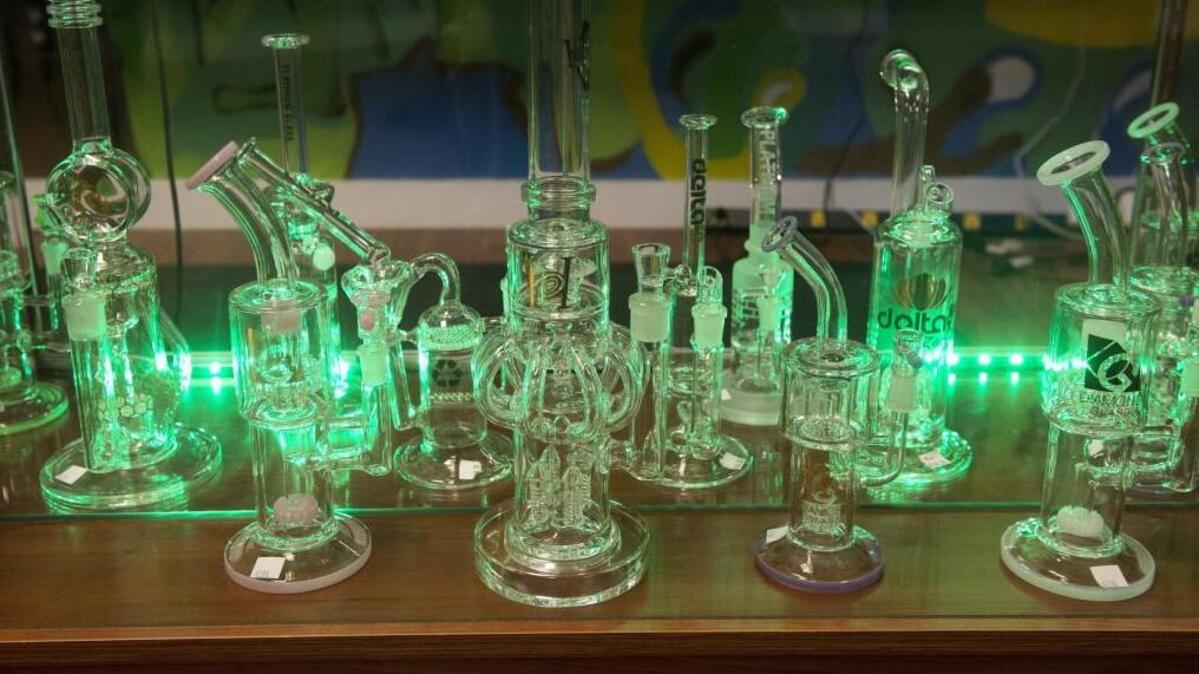 Glowing green backlighting illuminates paraphernalia at Green Collar, a retail marijuana business in Parkland. Green Collar has a state license and has met some county requirements. It has stayed open while awaiting a conditional-use permit after the county lifts its marijuana ban this summer. A Pierce County advisory vote on Tuesday made things more complicated, however.