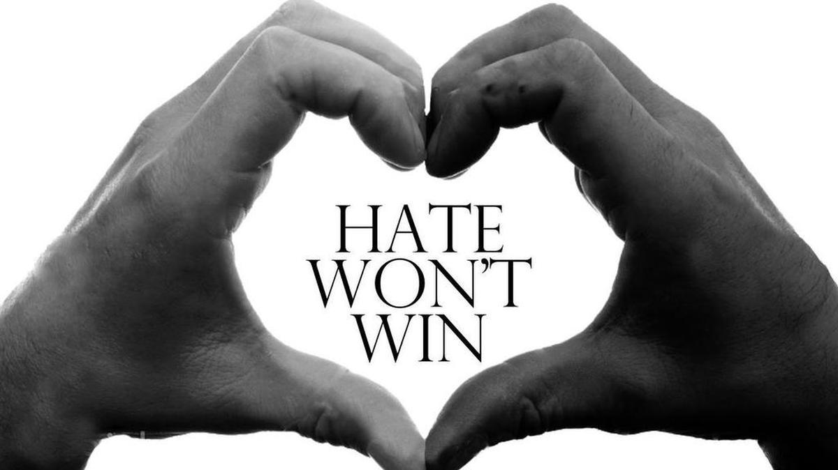 
The Hate Won’t Win symbol is a heart created by black and white hands.

