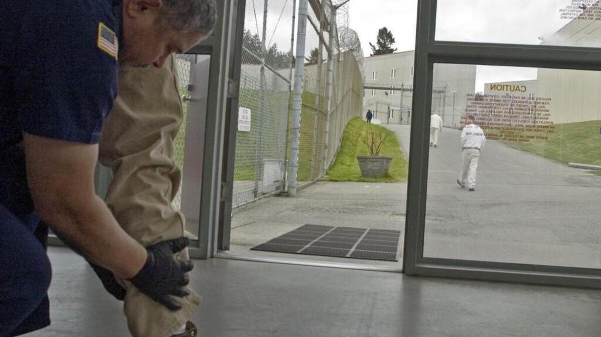 A corrections officer pats down an inmate at the former McNeil Island Correctional Center in 2009. More than 3,000 inmates are believed to have been mistakenly released early from state prisons since 2002.