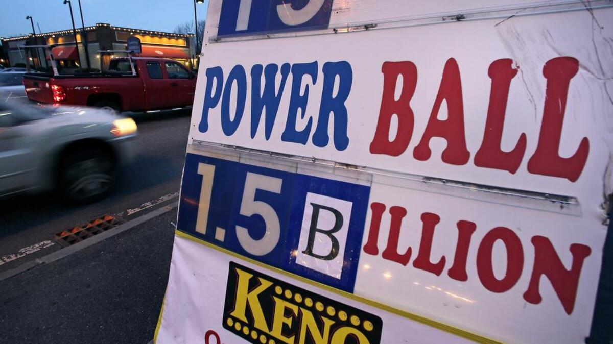 Commuters drive past a sign Tuesday showing the Powerball jackpot in Wednesday's drawing posted outside the Mobil Mart in Methuen, Massachusetts.