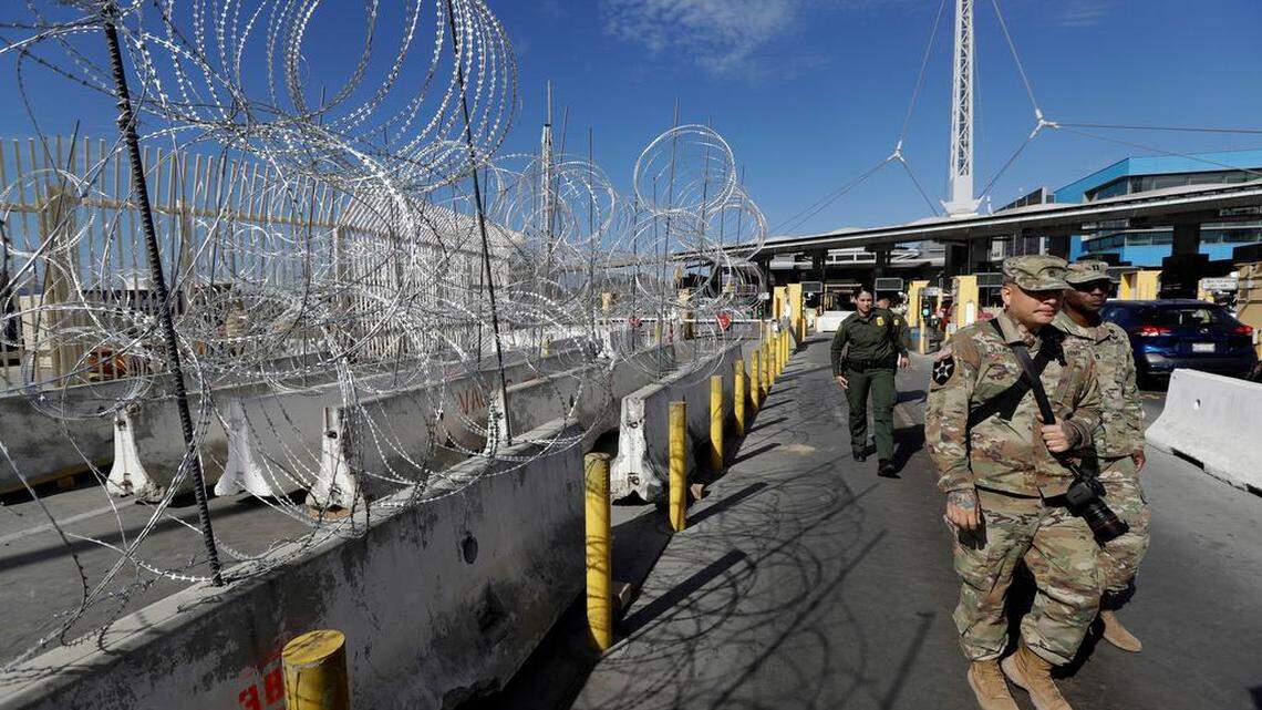 U.S. Border Patrol agents and members of the military pass concertina wire during a tour of the San Ysidro port of entry in San Diego. (AP Photo/Gregory Bull)