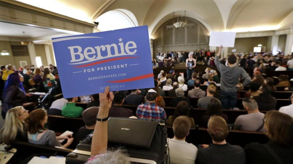 A Bernie Sanders supporter holds up a sign during the Democratic caucus Saturday at Seattle's Town Hall. Sanders won more than 70 percent support during the party’s statewide straw poll.