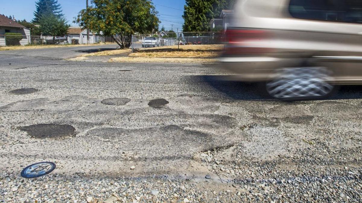 
A street in Tacoma’s Oakland neighborhood is pocked with an assortment of patches and potholes in June.
