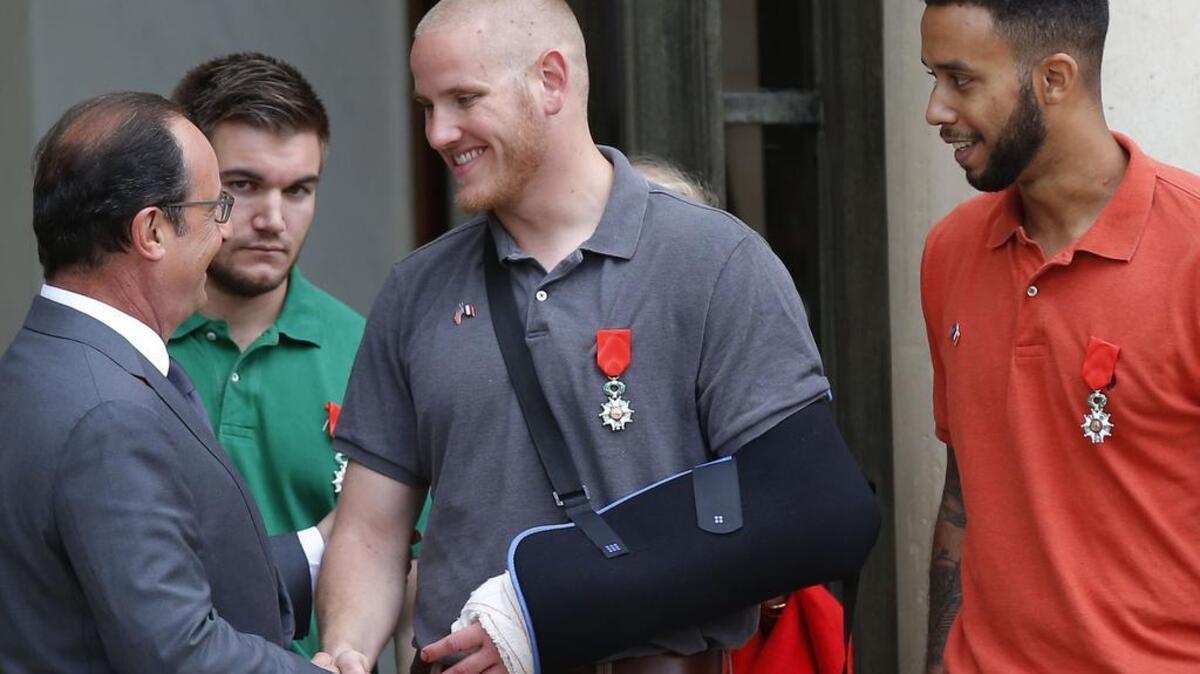 
French President Francois Hollande, left, shakes hands Monday with Airman Spencer Stone, who with Anthony Sadler, right, and U.S. National Guardsman Alek Skarlatos helped thwart a suspected terrorism attempt. 
