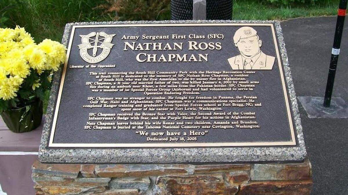 A plaque marks the 1.6-mile Nathan Chapman Memorial Trail, which cuts through woods and wetlands and joins South Hill Park with the Heritage Recreation Center. Chapman was a local Green Beret and the first of 316 JBLM service members killed in Afghanistan.