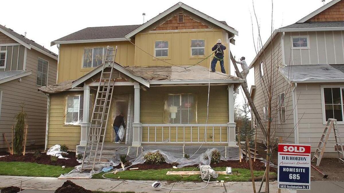 House painters spray on a color to the exterior of a home in the new Radiance housing subdivision in Fife in 2007. Property owners in the Fife School District are seeing their school tax rate go up this year due to a school bond measure approved by voters in 2018.