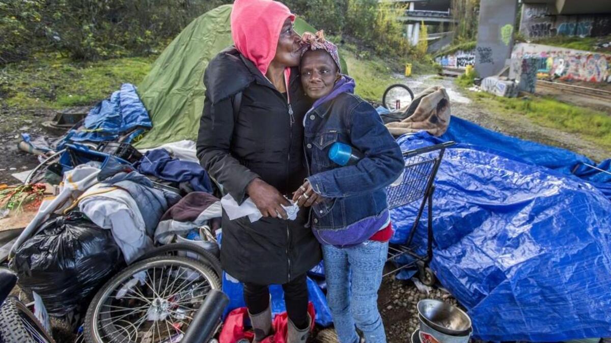 Owretha Riley, 60, and Ulonda Bell, 51, right, embrace while packing up their belongings to move out of "The Jungle," a large homeless encampment under the I-705 overpass in Tacoma on Tuesday, April 13, 2017.