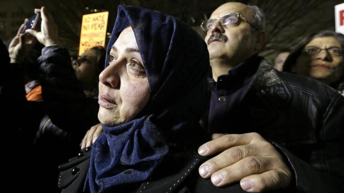 Emtisal Bazara cries as she and her husband, Ahmad Bazara, both recent Syrian immigrants, look on at a Jan. 29 rally in Seattle opposing President Donald Trump's executive order barring citizens from several countries from entering the U.S. The couple arrived in the Seattle area with two of their four children in December, four years after leaving Aleppo as refugees. They said their two adult children have been denied entry because of Trump's order.