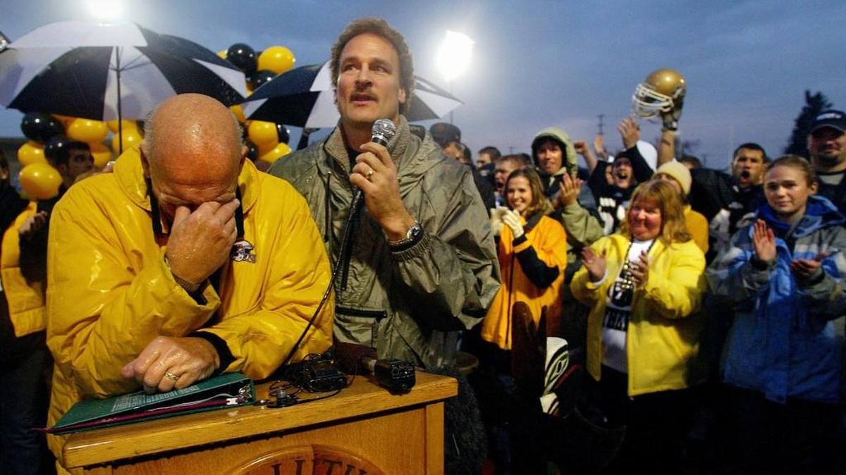 PLU football coach Frosty Westering (left) is overcome with emotion as his son Scott, the team's longtime offensive coordinator, pays tribute. The postgame ceremony lasted 30 minutes in a drizzle following the coach's last game before retiring in 2003. It ended with a rousing “Attaway” for the man who made the cheer famous. Scott Westering took over as head coach the following season. He won’t be back in 2018.