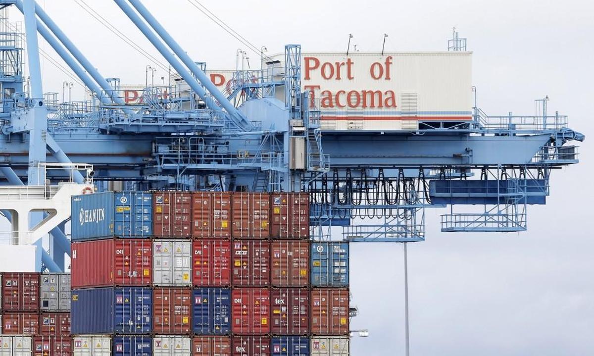 A Port of Tacoma crane is shown next to cargo containers on a ship docked at the Port in 2015.