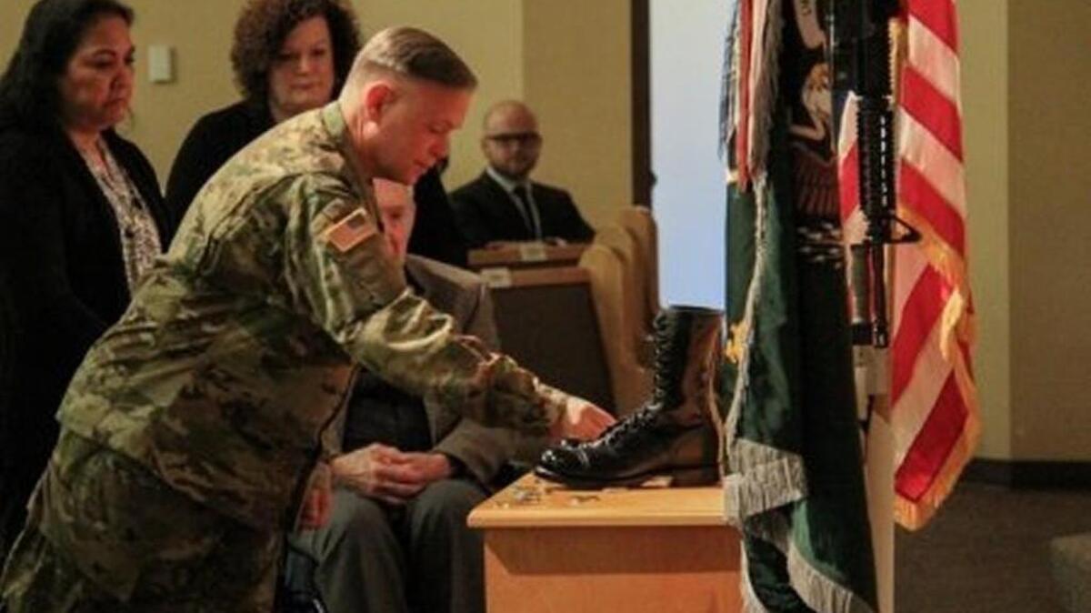 Maj. Gen. Bret Daugherty places a coin at the boots of Sgt. 1st Class Matthew McClintock during a fallen soldier memorial at Joint Base Lewis-McChord in February. McClintock, a member of Alpha Company, 1-19th Special Forces Group, was on his third combat tour when he was killed Jan. 5 in southern Afghanistan.