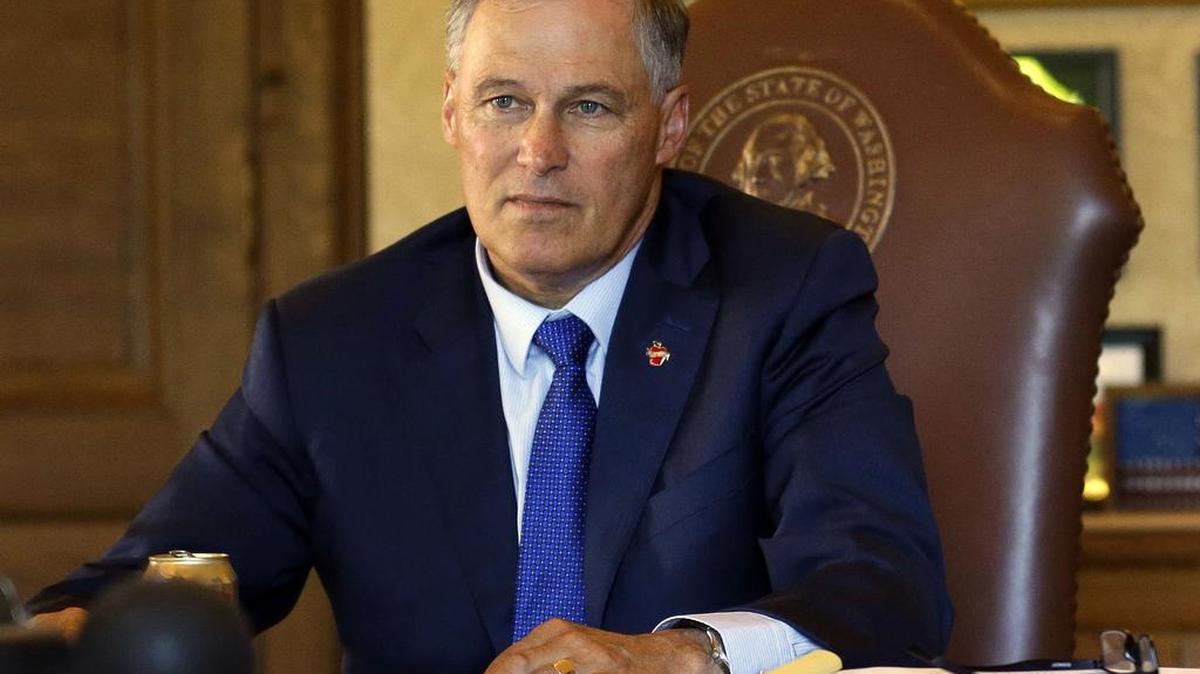 Gov. Jay Inslee meets with staff members in his office.
