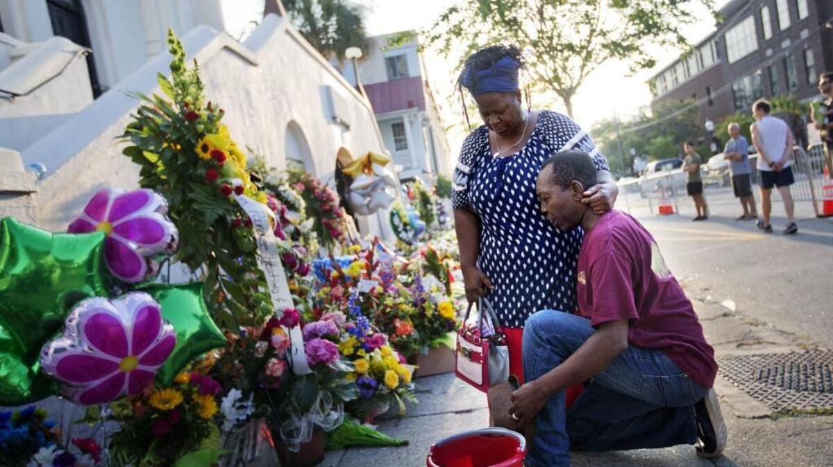 Prayers are lifted at a sidewalk memorial in memory of the shooting victims in front of Emanuel AME Church in Charleston, S.C. Dylann Roof was convicted Thursday of killing nine black people in June 2015 inside the church.