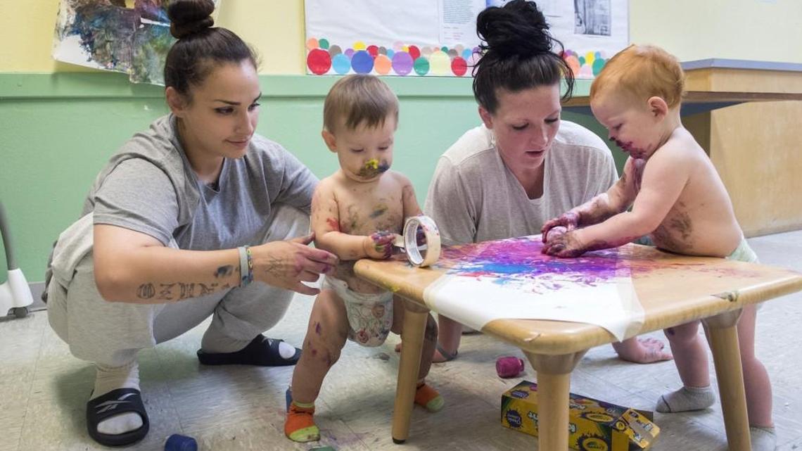 Candida Suarez, left, and Skye Logue watch with amusement as their sons, Ezra and Aceyn, make a mess playing with edible paint in the day room at the Washington Corrections Center for Women in Purdy.