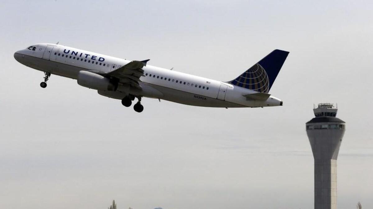 A United Airlines jet departs in view of the air traffic control tower at Seattle-Tacoma International Airport.