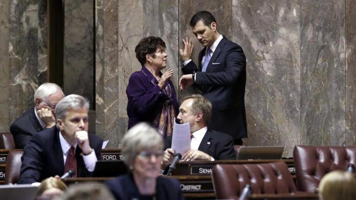 Republican state senators Pam Roach and Joe Fain talk before a vote during the 2015 Legislature. They belong to the local delegation whose 24 members represent districts that at least touch on Pierce County.