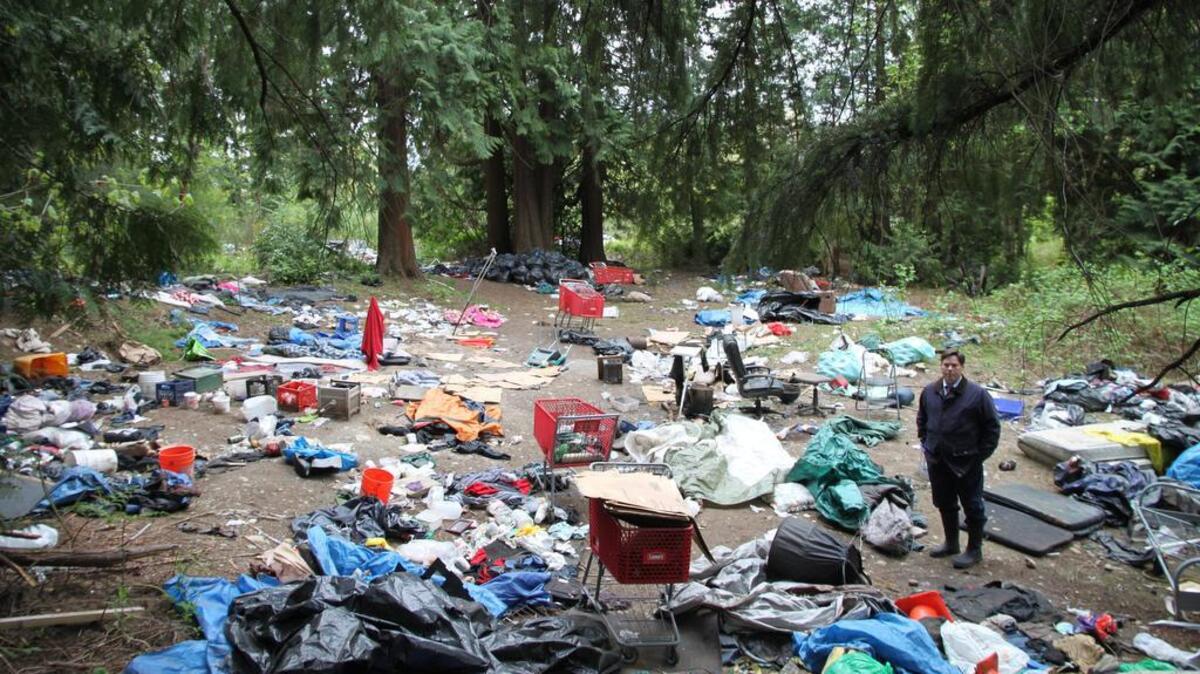Federal Way Mayor Jim Ferrell visits the site of a trash-strewn homeless encampment located along Pacific Highway South just west of South 350th Street.